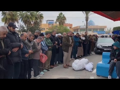 People gather to pray for the dead in front of Al Aqsa Hospital in Gaza