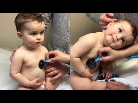 Sweet Baby Boy Rests Head On Nurse's Hand During Check-up