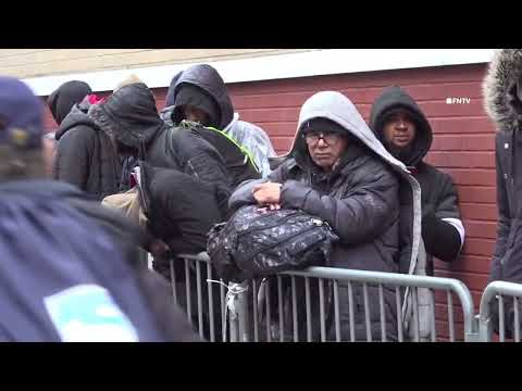 Long line of Migrants outside St Brigids in East Village under the rain