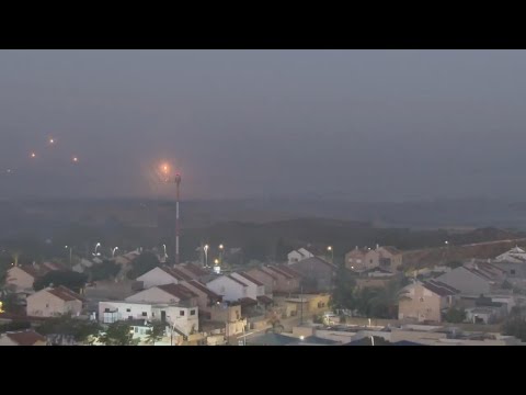 Flares drift over Gaza, smoke plumes billow into sky, a month after Israel-Hamas war started