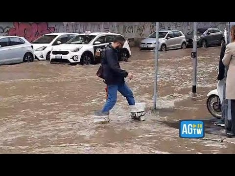 Milano allagata, c&rsquo;&egrave; chi per non bagnarsi infila due secchi ai piedi per attraversare la strada