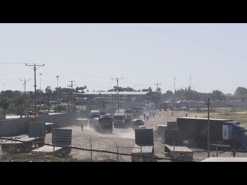 More trucks carrying aid enter Gaza through Rafah crossing, as smoke seen in distance