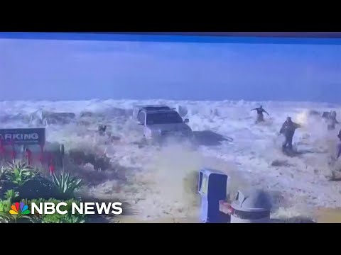 Californians flee from big waves as water breaks over a sea wall