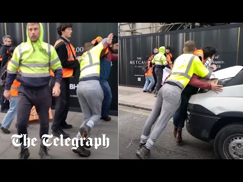 Angry workmen push Just Stop Oil protesters out of the road