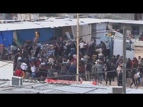 People take aid from trucks in Rafah in the Gaza Strip