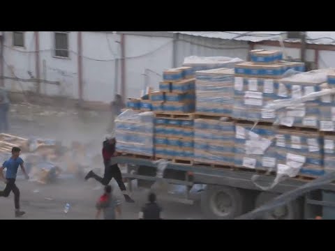 Chaotic scenes in Rafah as people throw aid from moving trucks