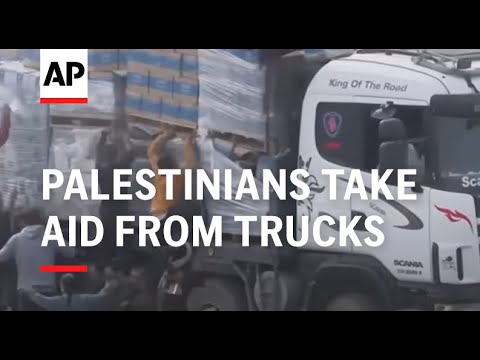 Palestinians take aid from trucks in Rafah in Gaza Strip