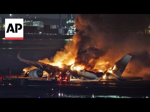 Plane bursts into flames on airport runway in Tokyo