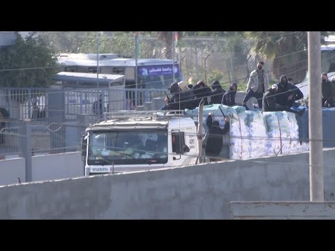 Masked men sit atop aid trucks leaving Rafah crossing into Gaza