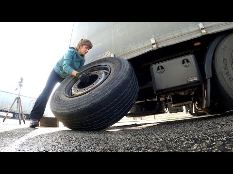 A day in the life of a female truck driver changing a flat tire