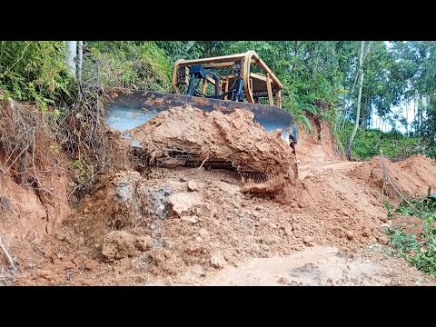 Extreme work cuts a hill on the edge of a ravine to repair the BULLDOZER D6R XL landslide road