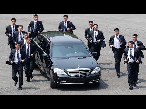 Kim Jong-un's bodyguards jog alongside limo